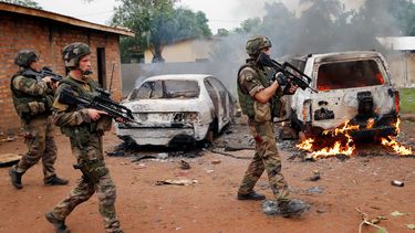 americateve | Soldados franceses pasan junto a dos veh&iacute;culos de la Seleka, una alianza de grupos rebeldes en su mayor&iacute;a musulmanes, incendiados por turbas cristianas en Bangui, capital de la Rep&uacute;blica Centroafricana, el lunes 9 de diciembre de 2013