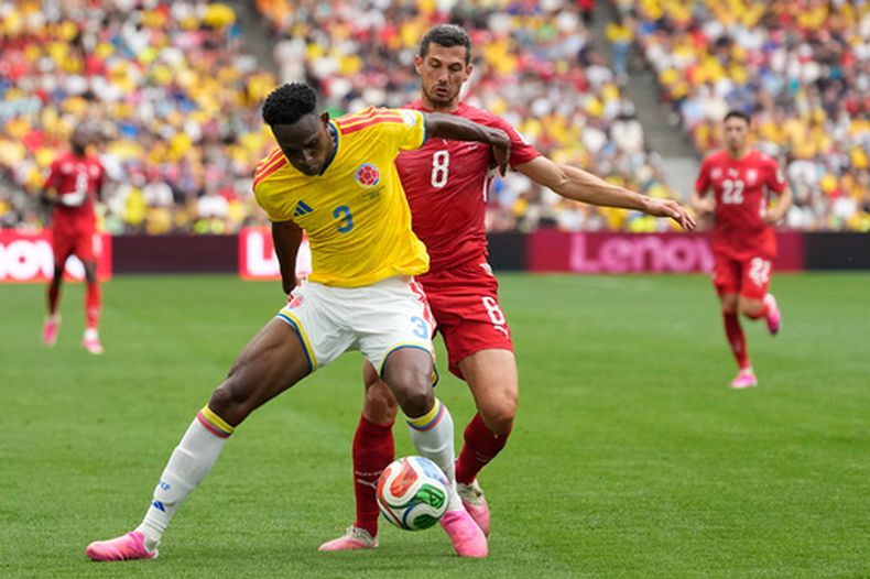 ARCHIVO - foto del 7 de julio del 2026, el colombiano Jhon Lucumí pelea por el balón con el suizo Remo Freuler en los octavos de final dela Copa Mundial. (AP Foto/Lindsey Wasson, Archivo)