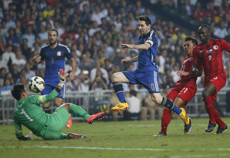El jugador de Argentina, Lionel Messi, anota un gol contra Hong Kong el martes, 14 de octubre de 2014, en Hong Kong. (AP Photo/Kin Cheung)