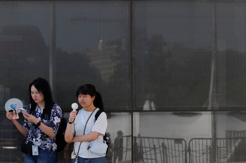 ARCHIVO – Visitantes se abanican mientras esperan entrar al Monumento a Washington, el 1 de julio de 2026, en Washington. (AP Foto/Tom Brenner, Archivo)