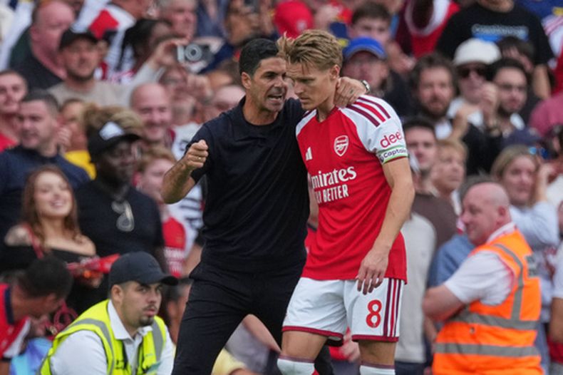 El técnico de Arsenal Mikel Arteta da instrucciones a Martin Odegaard durante el partido contra Chelsea en la Liga Premier, el domingo 6 de septiembre de 2026, en Londres. (AP Foto/Dave Shopland)