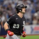 Andrew Benintendi (23), de los Medias Blancas de Chicago, corre las bases después de batear un jonrón frente a Nick Martinez, al fondo, lanzador de los Rays de Tampa Bay, durante la segunda entrada del juego de béisbol de Grandes Ligas del viernes 31 de julio de 2026, en San Petersburgo, Florida. (AP Foto/Jason Behnken)