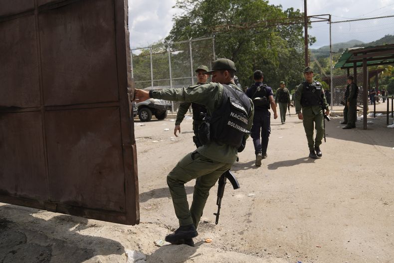 Un soldado cierra la puerta principal del centro penitenciario de Tocorón durante una intervención militar, en Tocorón, Venezuela, el miércoles 20 de septiembre de 2023. Militares ejecutaron la intervención en un intento de desmantelar una de las bandas criminales en el país, de acuerdo con el ministro de Interior, el almirante en jefe Remigio Ceballos. (AP Foto/Ariana Cubillos)