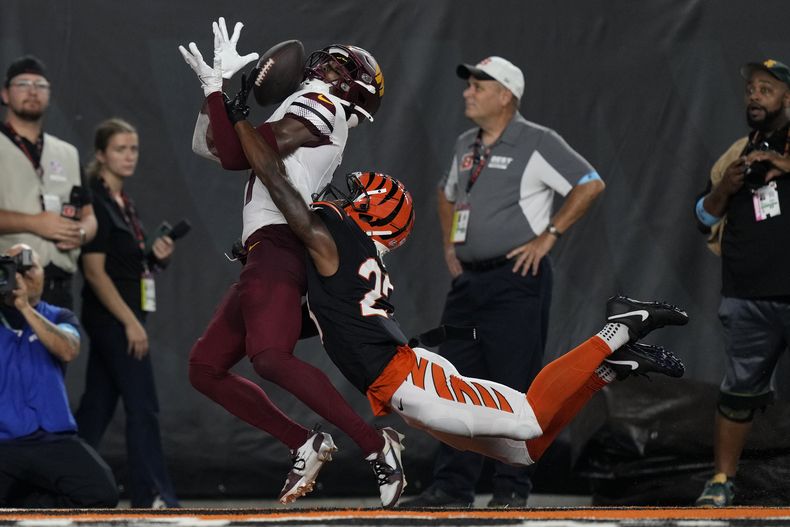 El wide receiver Terry McLaurin, izquierda, de los Commanders de Washington, atrapa un pase de touchdown de 27 yardas con el cornerback Dax Hill, de los Bengals de Cincinnati, encima de él, durante la segunda mitad del juego de la NFL, el lunes 23 de septiembre de 2024, en Cincinnati. (AP Foto/Carolyn Kaster)