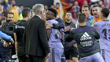 Vinicius Junior (centro) del Real Madrid pasa al lado de su técnico Carlo Ancelotti tras ser expulsado del partido contra el Valencia en la Liga de España, el domingo 21 de mayo de 2023. (AP Foto/Alberto Saiz)