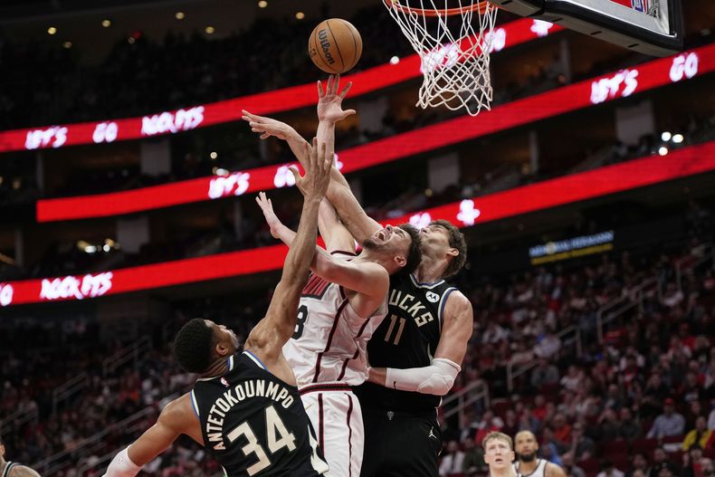 Alperen Sengun, de los Rockets de Houston, salta entre Giannis Antetokounmpo (34) y Brook López (11), de los Bucks de Milwaukee, el martes 25 de febrero de 2025 (AP Foto/David J. Phillip)