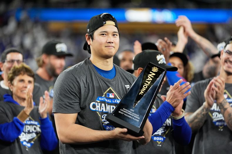 El pitcher de los Dodgers de Los Ángeles Shohei Ohtani celebra la victoria ante los Cerveceros de Milwaukee con el trofeo de campeón de la Serie de Campeonato de la Liga Nacional el viernes 17 de octubre del 2025. (AP Foto/Brynn Anderson)
