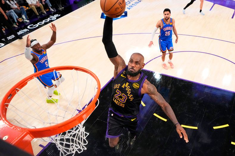 El alero de los Lakers de Los Ángeles LeBron James salta para clavar el balón frente a Luguentz Dort y Ajay Mitchell del Thunder de Oklahoma City en el juego 4 de las semifinales del Oeste el lunes 11 de mayo del 2026. (AP Foto/Mark J. Terrill)
