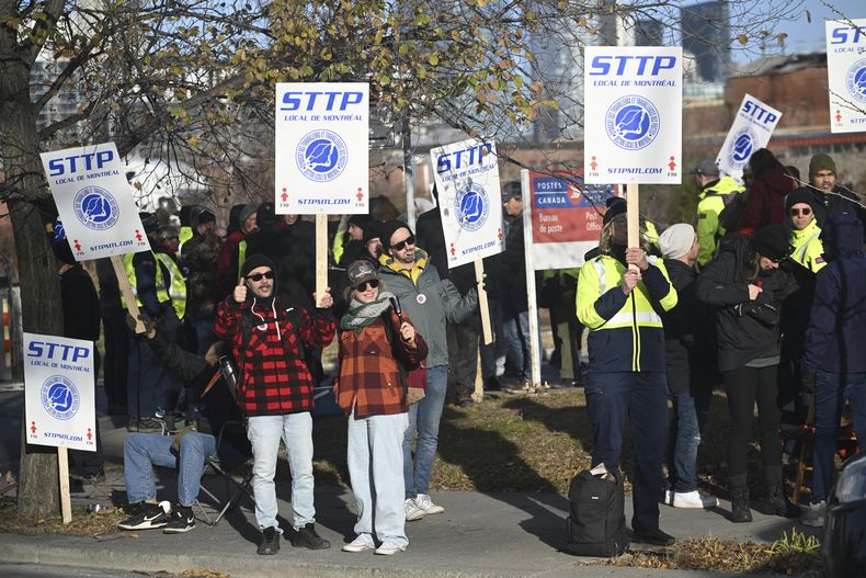 Trabajadores del servicio postal de Canadá se manifiestan afuera de un centro de reparto en Montreal, el viernes 15 de noviembre de 2024. (Graham Hughes/The Canadian Press vía AP)