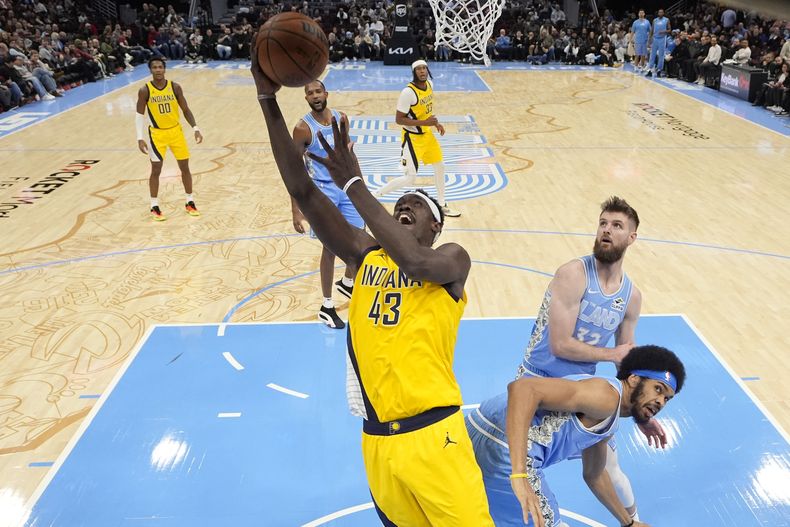 Pascal Siakam (43), de los Pacers de Indiana, se alista para encestar frente a Jarrett Allen, derecha, y Dean Wade, atrás, en la segunda mitad del juego de baloncesto de la NBA, el domingo 12 de enero de 2025, en Cleveland. (AP Foto/Sue Ogrocki)