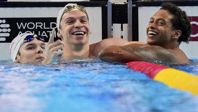 Leon Marchand (centro) celebra tras ganar la medalla de oro de los 200 metros combinados del Mundial de natación, el jueves 31 de julio de 2025, en Singapur. (AP Foto/Vincent Thian)