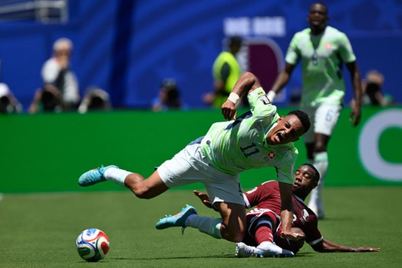 El suizo Dan Ndoye (izquierda) es derribado por el quatarí Assim Madibo durante el partido por el Grupo B del Mundial, el sábado 13 de junio de 2026, en Santa Clara, California. (AP Foto/Eakin Howard)