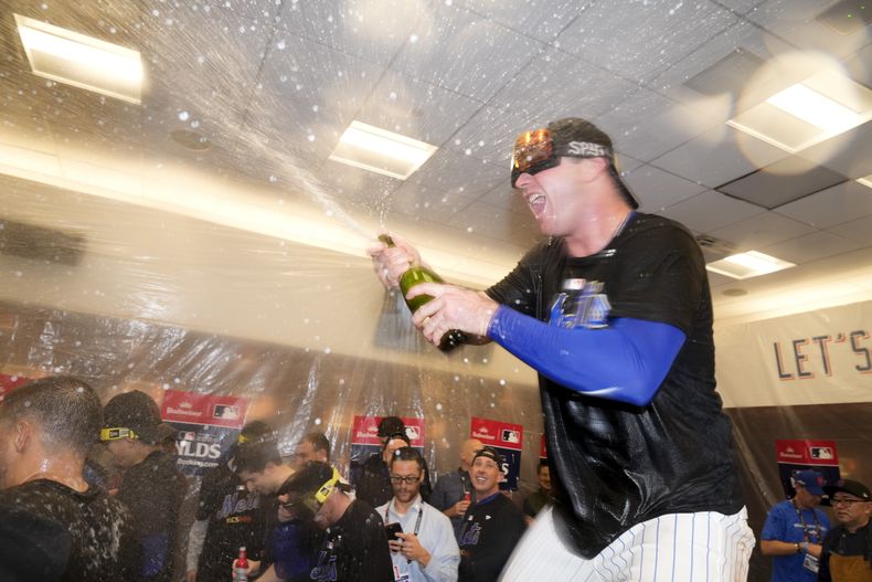 Pete Alonso, de los Mets de Nueva York, celebra en el vestidor después de superar a los Filis de Filadelfia en el cuarto juego de la serie divisional de la Liga Nacional, el miércoles 8 de octubre de 2024, en Nueva York. (AP Foto/Frank Franklin II)