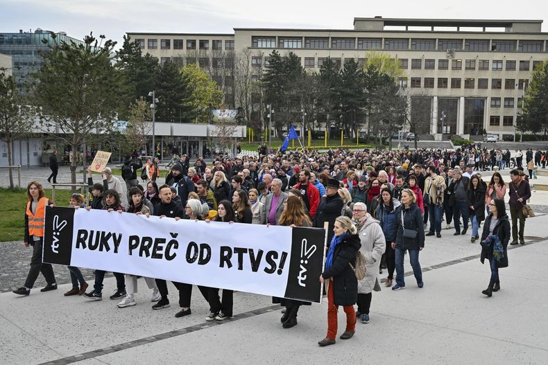Manifestantes sostienen una pancarta que dice ¡Manos fuera de RTVS! durante una protesta organizada por partidos de oposición eslovacos en Bratislava, el miércoles 27 de marzo de 2024, en contra del plan del gobierno de tomar el control de la emisora pública del país. (Pavol Zachar/TASR vía AP)