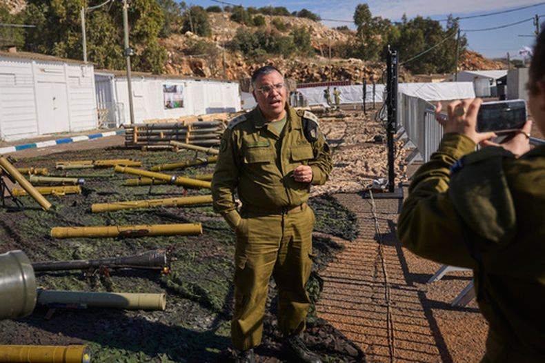 Avichay Adraee, el portavoz militar israelí en idioma árabe, junto con armas que según el ejército fueron incautadas al grupo libanés Hezbollah, en una base militar israelí en el norte de Israel, el 23 de diciembre del 2024. (AP foto/Ohad Zwigenberg)