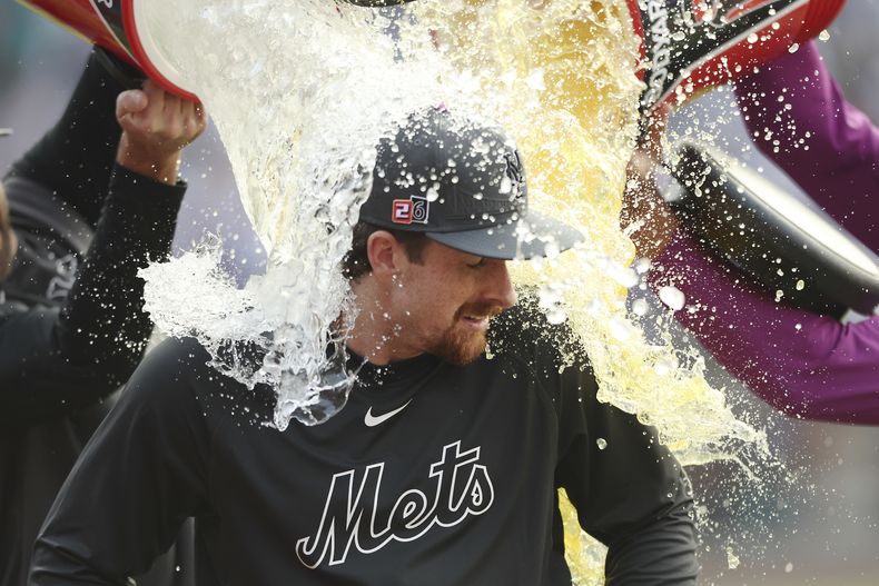 Nolan McLean, pitcher de los Mets de Nueva York, es empapado con la hielera tras ganar el juego del sábado 16 de agosto de 2025, ante los Marineros de Seattle (AP Foto/Heather Khalifa)