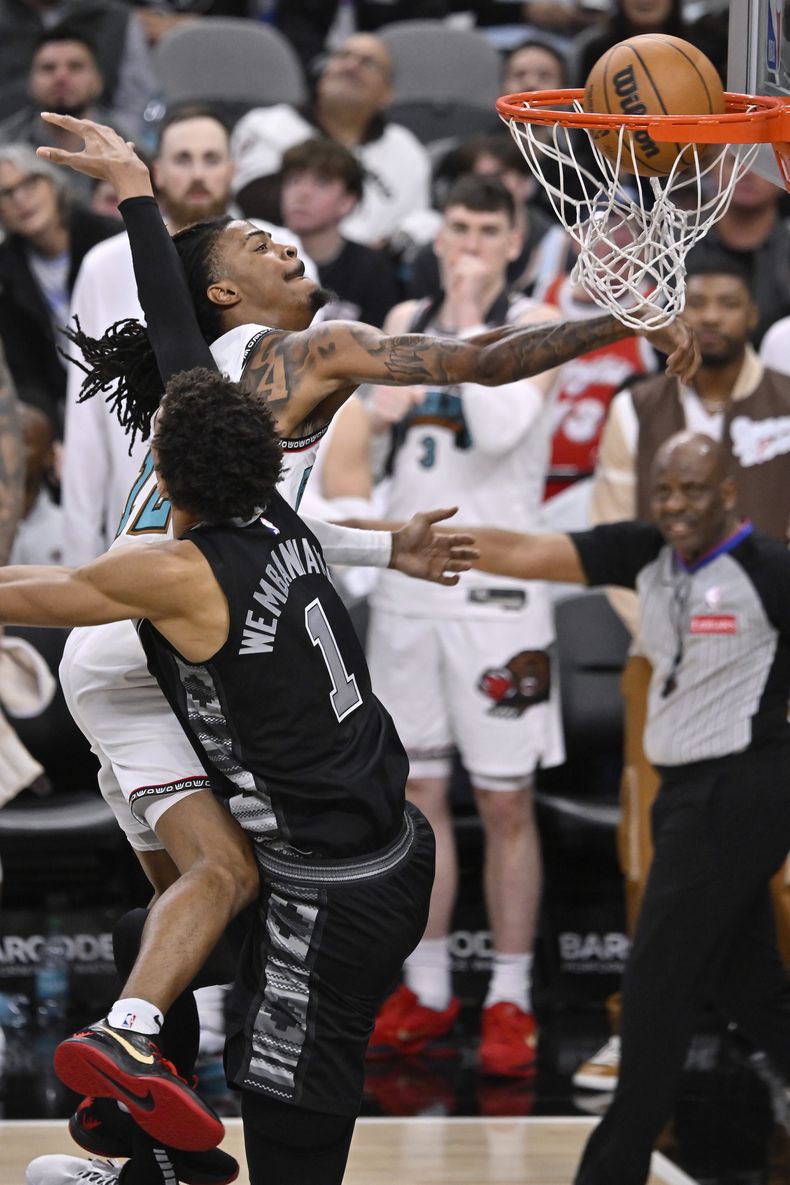 Ja Morant, de los Grizzlies de Memphis, clava el balón frente a Victor Wembanyama (1), de los Spurs de San Antonio, durante la segunda mitad del juego de baloncesto de la NBA del miércoles 15 de enero de 2024, en San Antonio. Memphis ganó 129-115. (AP Foto/Darren Abate)