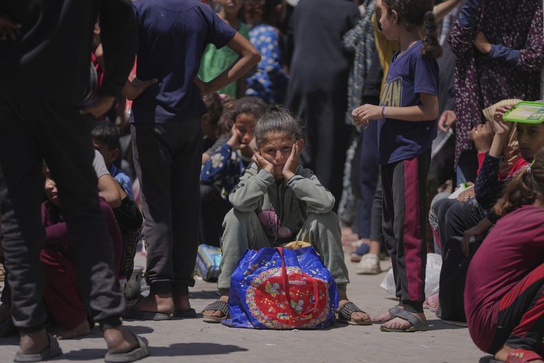 Una niña palestina espera para recoger alimentos donados en un centro de distribución en Deir al-Balah, Franja de Gaza, el viernes 30 de mayo de 2025. (AP Foto/Abdel Kareem Hana)