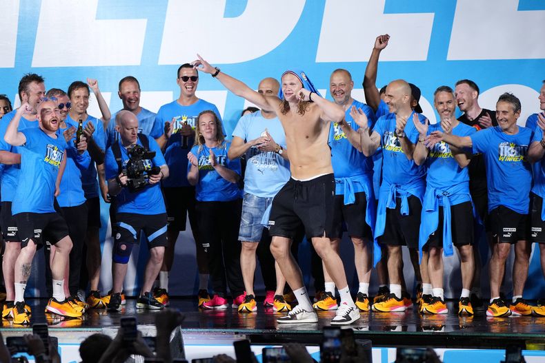 Erling Haaland y sus compañeros del Manchester City celebran frente a los aficionados tras conseguir la tripleta tras el desfile en Manchester el lunes 12 de junio del 2023. (AP Foto/Jon Super)