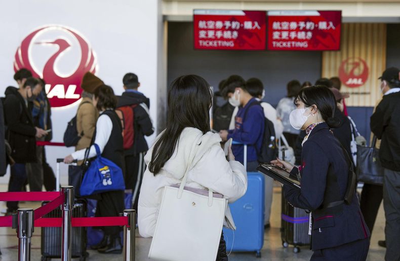 Una trabajadora de la aerolínea Japan Airlines ayuda a viajeros en el Aeropuerto Internacional de Osaka, a las afueras de Osaka, Japón, el 26 de diciembre de 2024, luego de que la compañía anunció que había sufrido un ciberataque. (Nobuki Ito/Kyodo News vía AP)