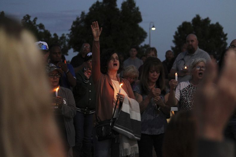 Miembros de la comunidad cantan durante una vigilia religiosa en la iglesia Hills, el lunes 15 de mayo de 2023 en Farmington, Nuevo México. Un hombre de 18 años disparó al azar en la localidad hacia autos y casas el lunes antes de morir abatido, en un tiroteo que dejó tres muertos y seis heridos, incluidos dos agentes de policía. (AP Foto/Susan Montoya Bryan)