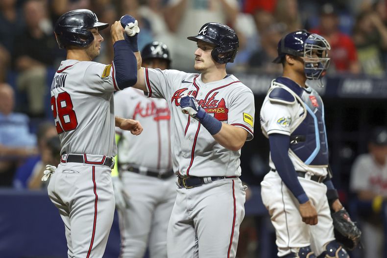 Sean Murphy de los Bravos de Atlanta celebra su jonrón de dos carreras con Matt Olson, junto al cátcher de los Rays de Tampa Bay Christian Bethancourt en el encuentro del viernes 7 de julio del 2023. (AP Foto/Mike Carlson)