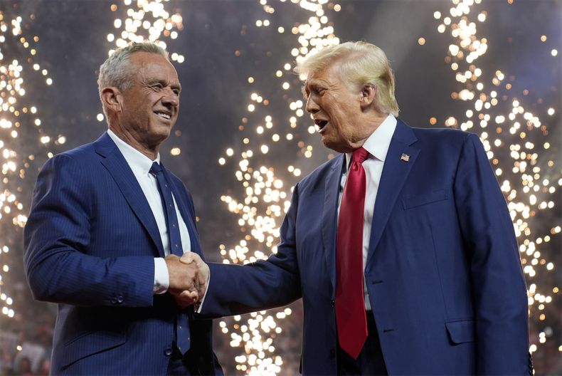 El candidato presidencial republicano Donald Trump estrecha la mano del candidato presidencial independiente Robert F. Kennedy Jr. en un acto de campaña en el Desert Diamond Arena, el viernes 23 de agosto de 2024, en Glendale, Arizona. (Foto AP/Evan Vucci).