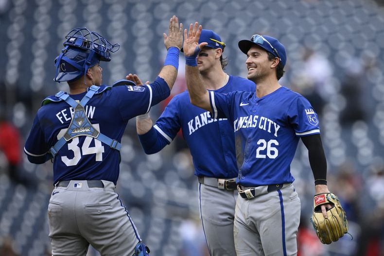 El receptor de los Reales de Kansas City, Freddy Fermín (34), Adam Frazier (26) y Bobby Witt Jr., de espalda, celebran después de un juego contra los Nacionales de Washington, el jueves 26 de septiembre de 2024, en Washington. Los Reales ganaron 7-4. (AP Foto/Nick Wass)