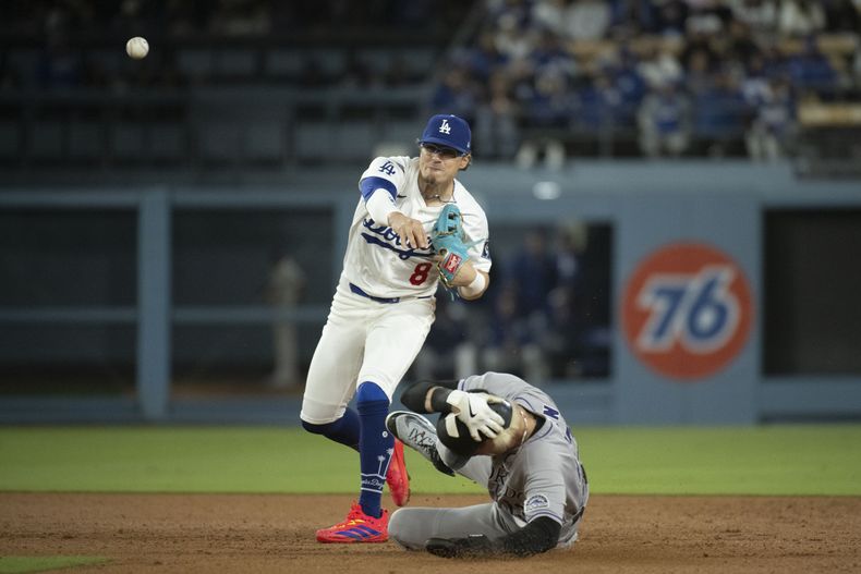 El segunda base de los Dodgers de Los Ángeles Enrique Hernández (8) lanza a primera para completar un doble play ante la barrida de Zac Veen durante la séptima entrada del juego de béisbol de Grandes Ligas el lunes 14 de abril de 2025, en Los Ángeles. Adael Amador fue puesto fuera en primera. (AP Foto/Kyusung Gong)