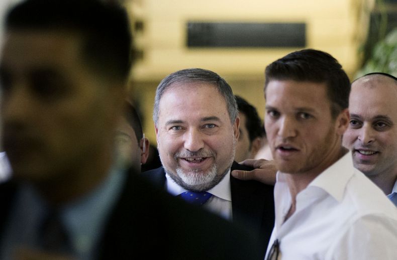 El ex ministro de relaciones exteriores Avigdor Lieberman, centro,  en una foto del 6 de noviembre del 2013, sonr&iacute;e a su saliida del Tribunal de Magistrados en Jerusal&eacute;n. El pol&iacute;tico radical regres&oacute; al cargo de canciller el lun