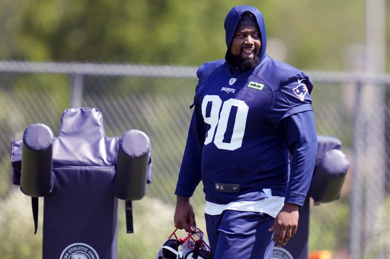 El tackle defensivo de los Patriots de New England, Christian Barmore (90) observa a sus commpañeros durante el campamento de entrenamiento de NFL, el viernes 26 de julio de 2024, en Foxborough, Massachusetts. (AP Foto/Charles Krupa)