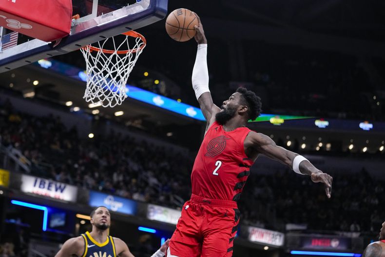 Deandre Ayton (2), de los Trail Blazers de Portland, se alza para clavar el balón ante la mirada lejana de Tyrese Haliburton (0), de los Pacers de Indiana, durante la primera mitad del juego de baloncesto de la NBA, en Indianápolis, el lunes 27 de noviembre de 2023. (AP Foto/Michael Conroy)
