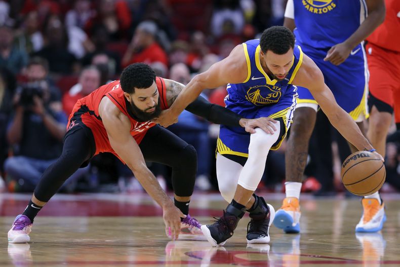 El base de los Warriors de Golden State Stephen Curry (derecha) trata de mantener control del balón ante la llegada del base de los Rockets de Houston, Fred VanVleet (izquierda) durante la 1ra mitad del juego en Houston, el domingo 29 de octubre de 2023. (AP Foto/Michael Wyke)