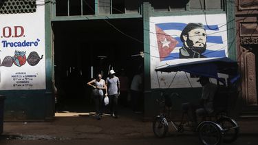 Clientes salen de un mercado agrario estatal donde un mural de Fidel Castro decora la fachada, en La Habana, Cuba, el jueves 7 de marzo de 2024. La libreta de abastecimiento cubana atemperaba las diferencias económicas entre la población y era un elemento clave en el momento socialista. Pero las cosas han cambiado y en las últimas protestas la consigna de los manifestantes fue corriente y comida, en alusión a los recurrentes apagones y el desabastecimiento de alimentos. (AP Foto/Ariel Ley)