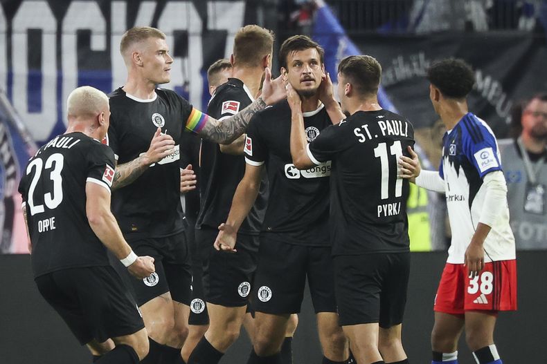 Adam Dzwigala del St. Pauli celebra con sus compañeros tras anotar en el encuentro ante el Hamburger en la Bundesliga el viernes 29 de agosto del 2025. (Christian Charisius/dpa via AP)