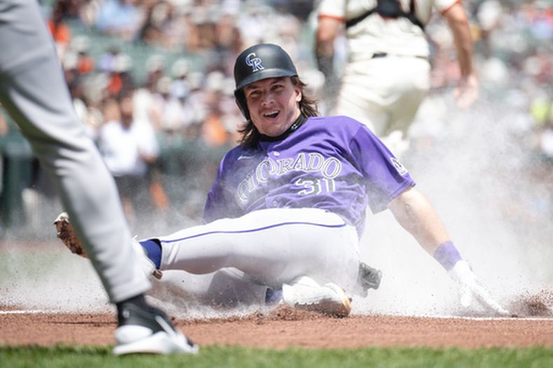 Jake McCarthy, de los Rockies de Colorado, se desliza en el plato de home para anotar una carrera durante la primera entrada de un partido de béisbol contra los Gigantes de San Francisco, el domingo 12 de julio de 2026, en San Francisco. (Foto AP/Thien-An Truong)