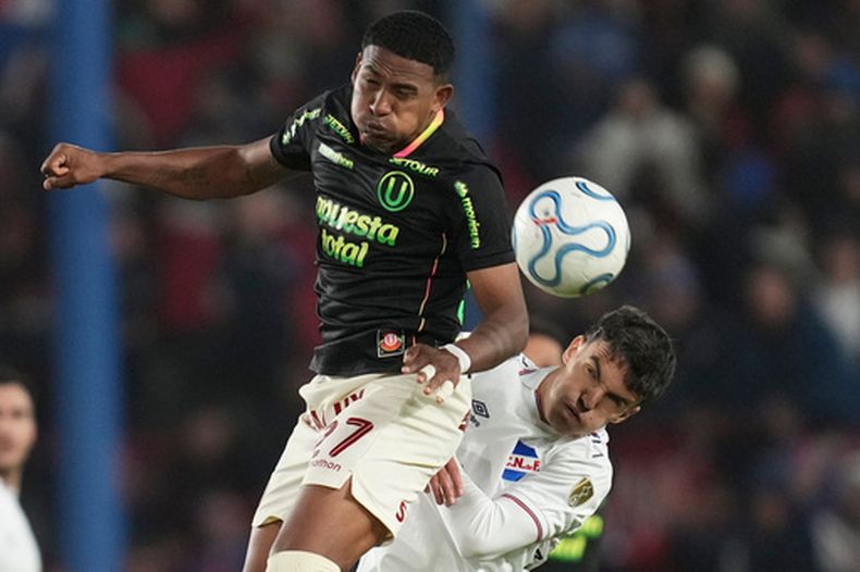 José Carabali, de Universitario de Perú, disputa un centro con Tomás Verón, de Nacional de Uruguay, en un encuentro de la Copa Libertadores, disputado el miércoles 20 de mayo de 2026 en Montevideo (AP Foto/Matilde Campodonico)