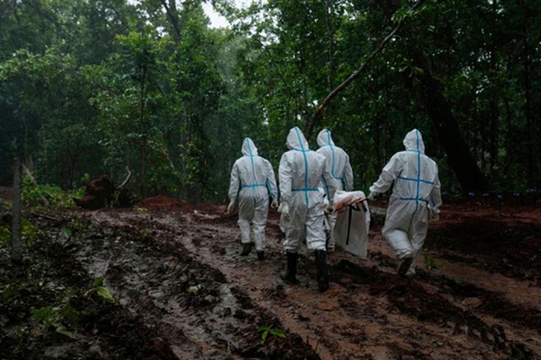 Miembros de las fuerzas paramilitares de Nepal transportan el cuerpo de una víctima de una crecida repentina, para su inhumación en una fosa común en Chitwan, Nepal, el lunes 31 de agosto de 2026. (Foto AP/Dar Yasin)