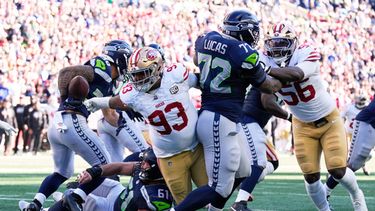 Gracen Halton (93), tackle defensivo de los 49ers de San Francisco, le arranca el balón a George Holani (36), corredor de los Seahawks de Seattle, durante la primera mitad del partido de la NFL, el domingo 11 de octubre de 2026, en Seattle. (AP Foto/Stephen Brashear)
