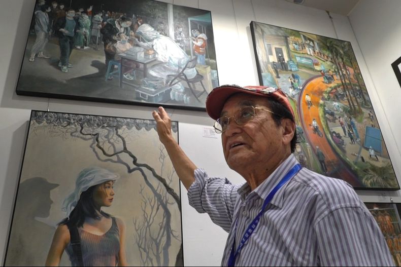 Zeng Fanzhi, un arquitecto jubilado convertido en artista, señala una de sus pinturas que retrata una prueba de COVID durante una entrevista en su estudio en Shenzhen, en el sur de China, en la provincia de Guangdong el 8 de septiembre de 2023. Zeng retrató la política cero-COVID de China para capturar un momento único en la historia. (Foto AP/Dake Kang)