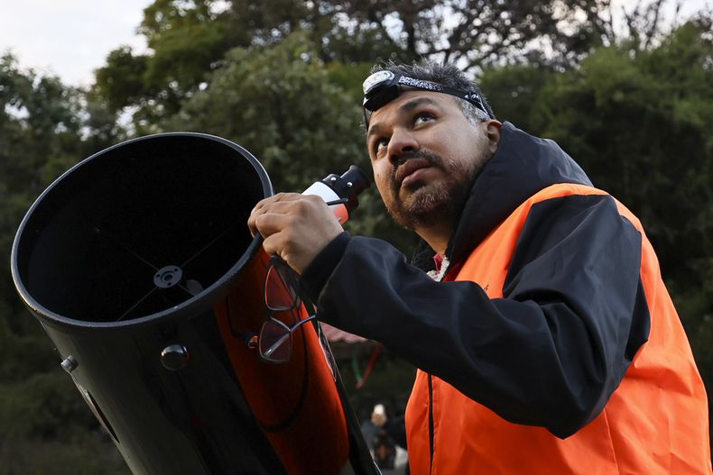 Juan Carlos Hernández, presidente de la Asociación Astronómica de Querétaro, coloca un telescopio para una sesión de observación de estrellas y cometas en el Parque Ecológico Joya-La Barreta en Querétaro, México, el sábado 19 de octubre de 2024. (AP Foto/Ginnette Riquelme)