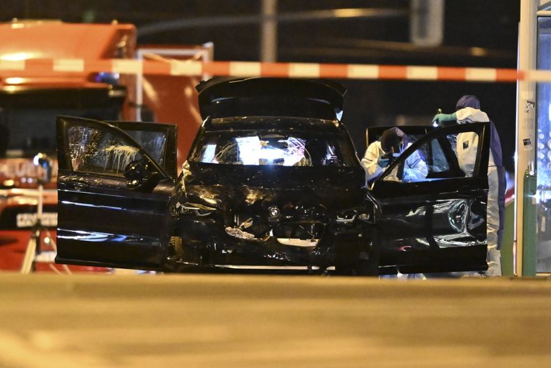 Forenses trabajan en un auto dañado con las puertas abiertas después de que un conductor arremetiera contra un bullicioso mercado navideño en Magdeburgo, Alemania, la madrugada del sábado 21 de diciembre de 2024. (Hendrik Schmidt/dpa via AP)
