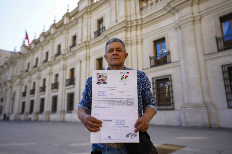 Fredy Maureira, padre de Valentina, que sufría fibrosis quística y murió a los 14 años, sostiene una copia de la carta que entregó en el palacio presidencial solicitando una reunión con el presidente, Gabriel Boric, en Santiago, Chile, el 24 de marzo de 2025. (AP Foto/Esteban Félix)