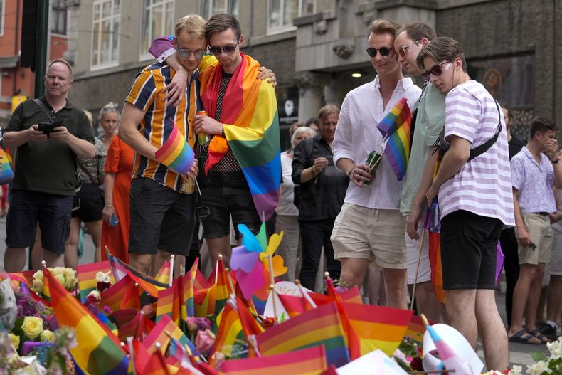 ARCHIVO - Un grupo de personas deposita flores en el lugar donde se registró un tiroteo en el centro de Oslo, Noruega, el sábado 25 de junio de 2022. (AP Foto/Sergei Grits, archivo)