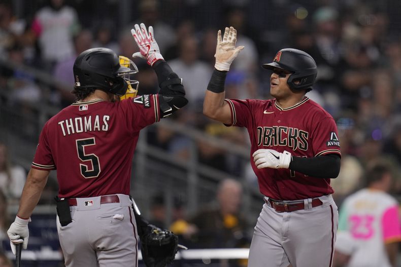 El venezolano Gabriel MOreno festeja con Alek Thomas, su compañero en los Diamondbacks de Arizona, luego de batear un jonrón en el duelo del jueves 17 de agosto de 2023, ante los Padres de San Diego (AP Foto/Gregory Bull)