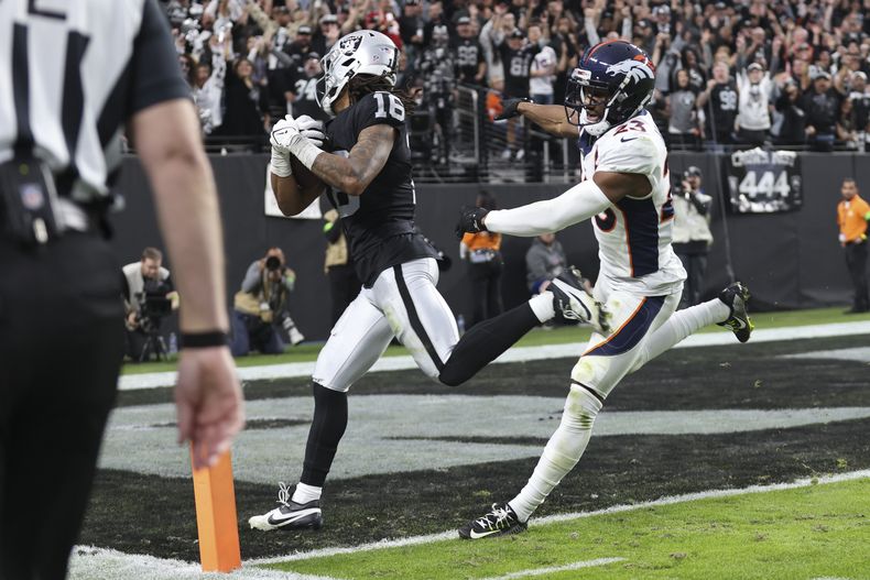 El wide receiver Jakobi Meyers (16), de los Raiders de Las Vegas, anota un touchdown frente al cornerback Fabian Moreau (23), de los Broncos de Denver, durante la segunda mitad del juego de la NFL, el domingo 7 de enero de 2024, en Las Vegas. (AP Foto/Ellen Schmidt)