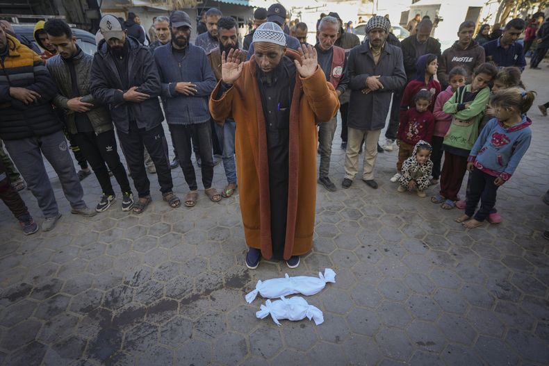 El imán Islam Abu Suaied ora ante los cuerpos de dos bebés antes de su sepelio en el hospital Mártires de Al-Aqsa en Deir al-Balah, en el centro de la Franja de Gaza, el 29 de diciembre de 2024. Uno de los bebés murió al nacer, mientras que el otro, Jomaa al-Batran, de 20 días de nacido, sucumbió a la hipotermia. Según autoridades sanitarias locales, al menos otros tres bebés murieron de frío en Gaza en las últimas semanas. (AP Foto/Abdel Kareem Hana)
