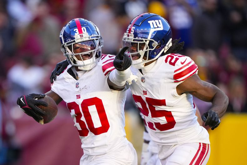 El cornerback de los Giants de Nueva York Darnay Holmes (30) celebra su intercepción junto a su compañero Deonte Banks (25) ante los Commanders de Washington durante la 2da mitad del juego de la NFL, el domingo 19 de noviembre de 2023, en Landover, Maryland. (AP Foto/Andrew Harnik)