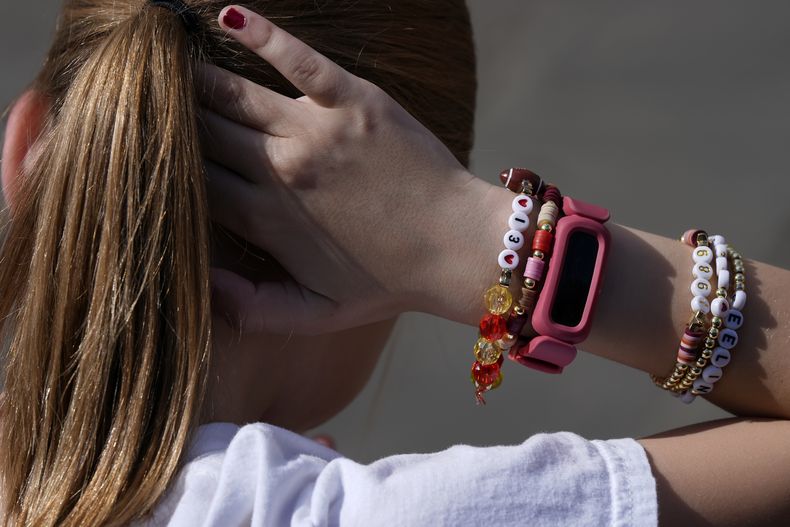 Rose Loftus, de 9 años, fan de los Chiefs de Kansas City originaria de Dallas, se recoge el cabello mientras usa un brazalete de la amistad de Taylor Swift afuera de la Catedral de St. Louis antes del Super Bowl 59 de a NFL entre los Chiefs y los Eagles de Filadelfia, el domingo 9 de febrero de 2025, en Nueva Orleans. (Foto AP/Julia Demaree Nikhinson)