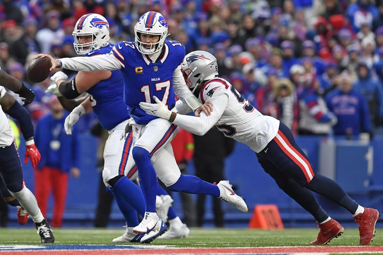 El quarterback Josh Allen corre y estira el balón para cruzar la línea de goal, mientras Josh Uche, linebacker de los Patriots de Nuev Inglaterra, durante la segunda mitad del juego de la NFL, el domingo 31 de diciembre de 2023. (AP Foto/Adrian Kraus)